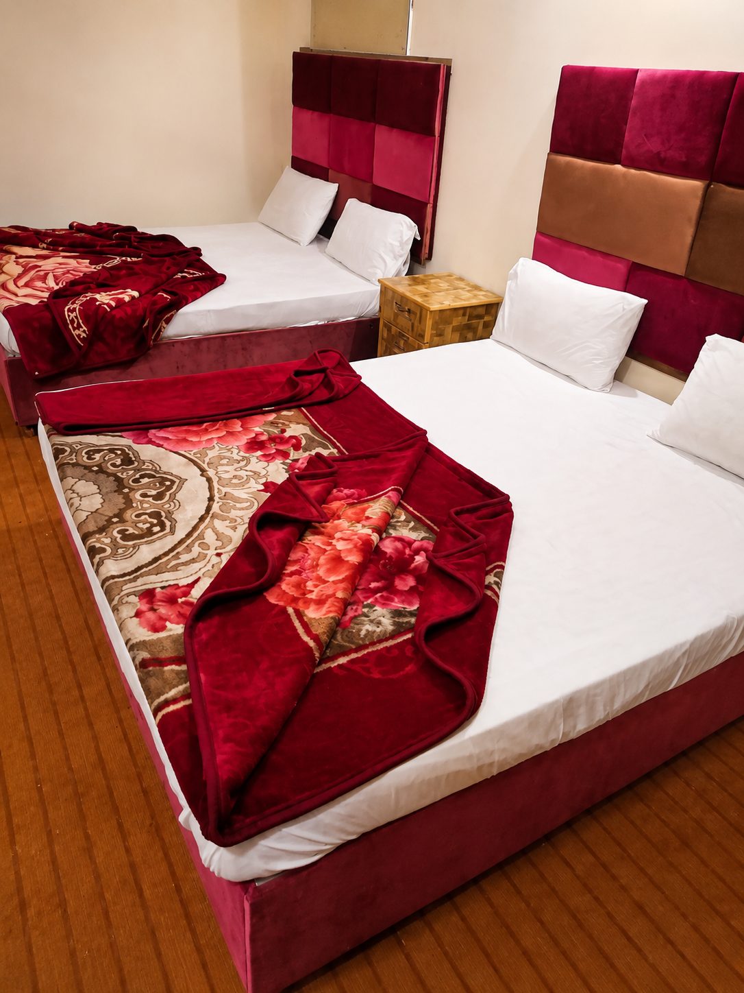 Triple bedroom with two beds and red velvet headboards