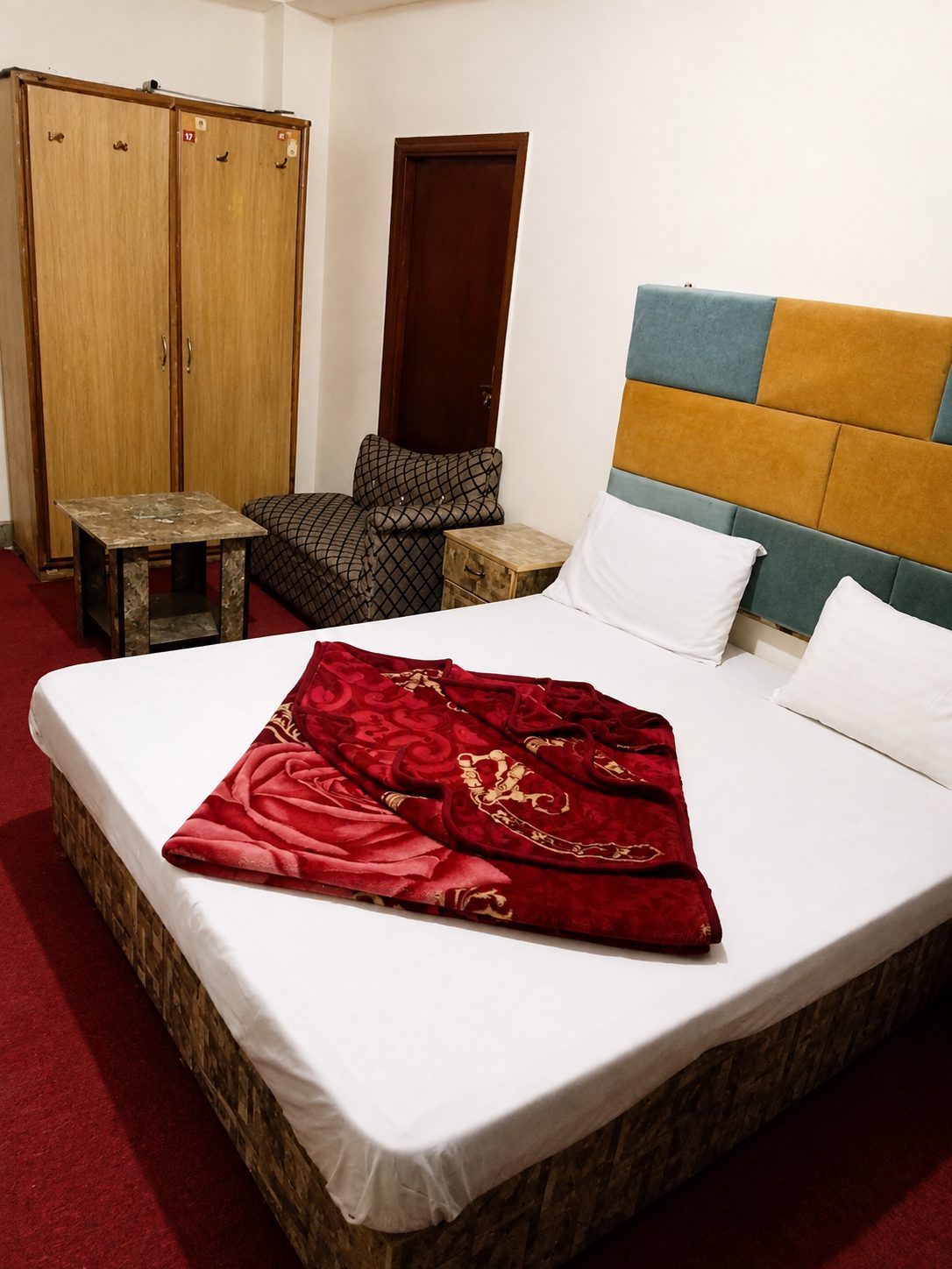 Air-conditioned triple bedroom with striped headboard and red carpet