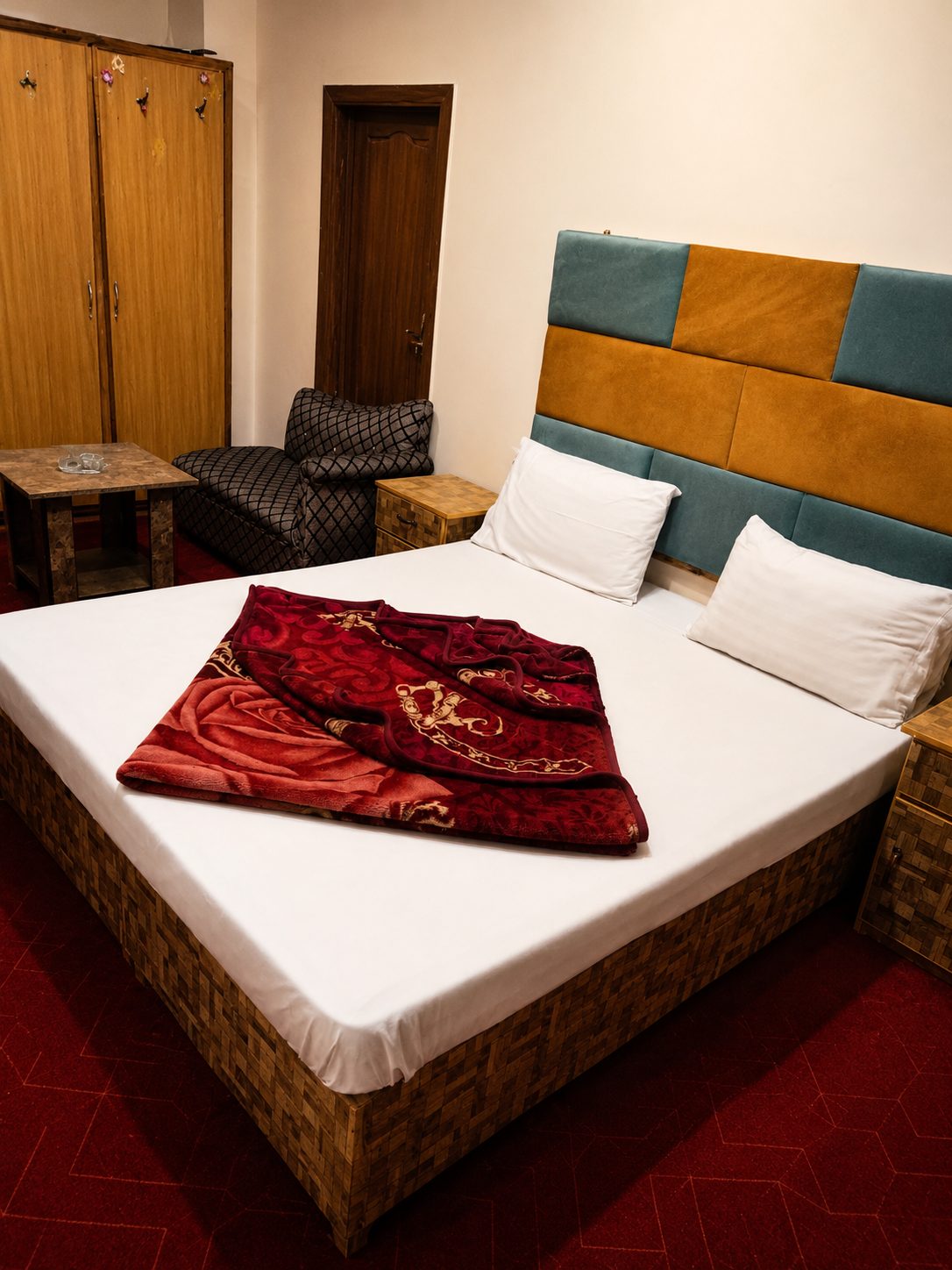 Guest room with colourful headboard and red blanket