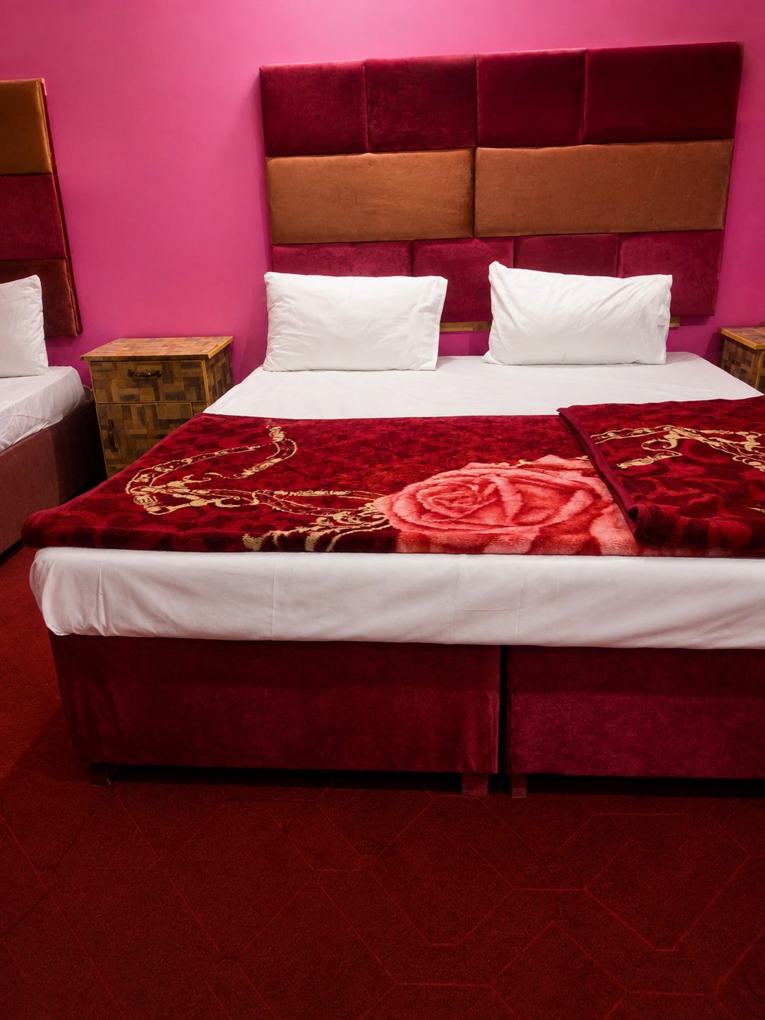 Vibrant rose-toned room with red velvet bedspread